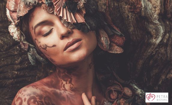 Intuitives Frauenporträt mit geschlossenen Augen, Tattoos und floralem Details - Deine Einzigartigkeit ist deine Magie